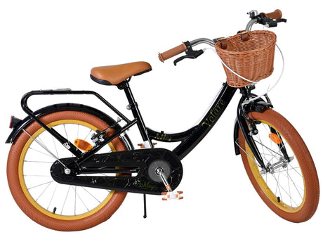 Schwarzes Kinderfahrrad mit Korb, braunen Reifen und gepolsterter Sitzfläche