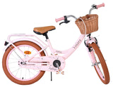 Rosa Damenfahrrad mit Korb und braunen Reifen