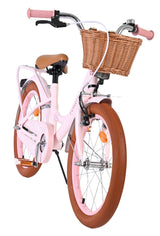 Rosa Kinderfahrrad mit Korb und braunen Reifen