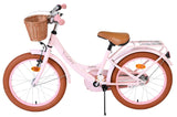 Rosa Kinderfahrrad mit Korb, braunen Reifen und beigem Sattel