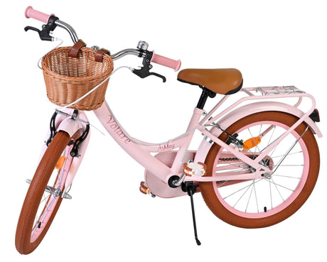 Rosa Damenfahrrad mit Korb und braunen Reifen