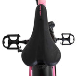 Schwarzer Fahrradsattel mit pinken Akzenten und Pedalen im Hintergrund
