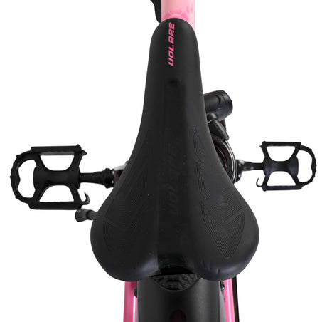 Schwarzer Fahrradsattel mit pinken Akzenten und Pedalen im Hintergrund