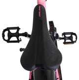 Schwarzer Fahrradsattel mit pinken Akzenten und Pedalen von oben betrachtet