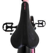 Schwarzer Fahrradsattel mit ergonomischem Design und Pedalen im Hintergrund