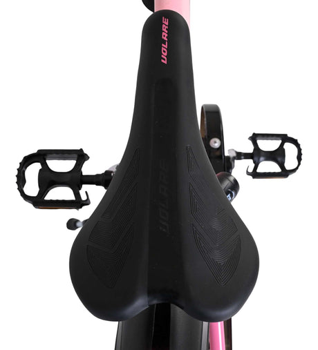 Schwarzer Fahrradsattel mit ergonomischem Design und Pedalen im Hintergrund