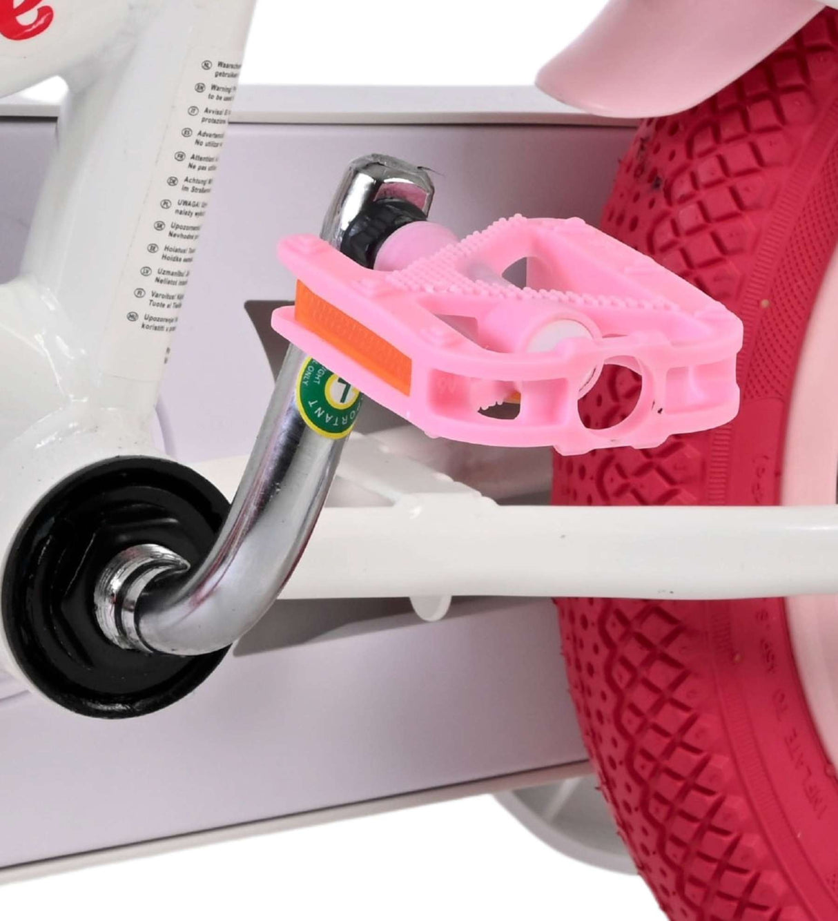 Rosa Fahrradpedal an einem weißen Kinderfahrrad mit rotem Reifen