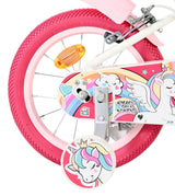 Rosa Fahrrad mit Einhorn-Motiv und bunten Reifen und Pedalen