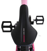 Schwarzer Fahrradsattel mit pinken Akzenten und Pedalen im Hintergrund