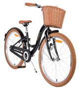 Schwarzes Fahrrad mit Korb, braunen Reifen und gepolstertem Sattel