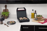 George Foreman Kontaktgrill in der Küche mit geöffnetem Deckel und Küchenutensilien